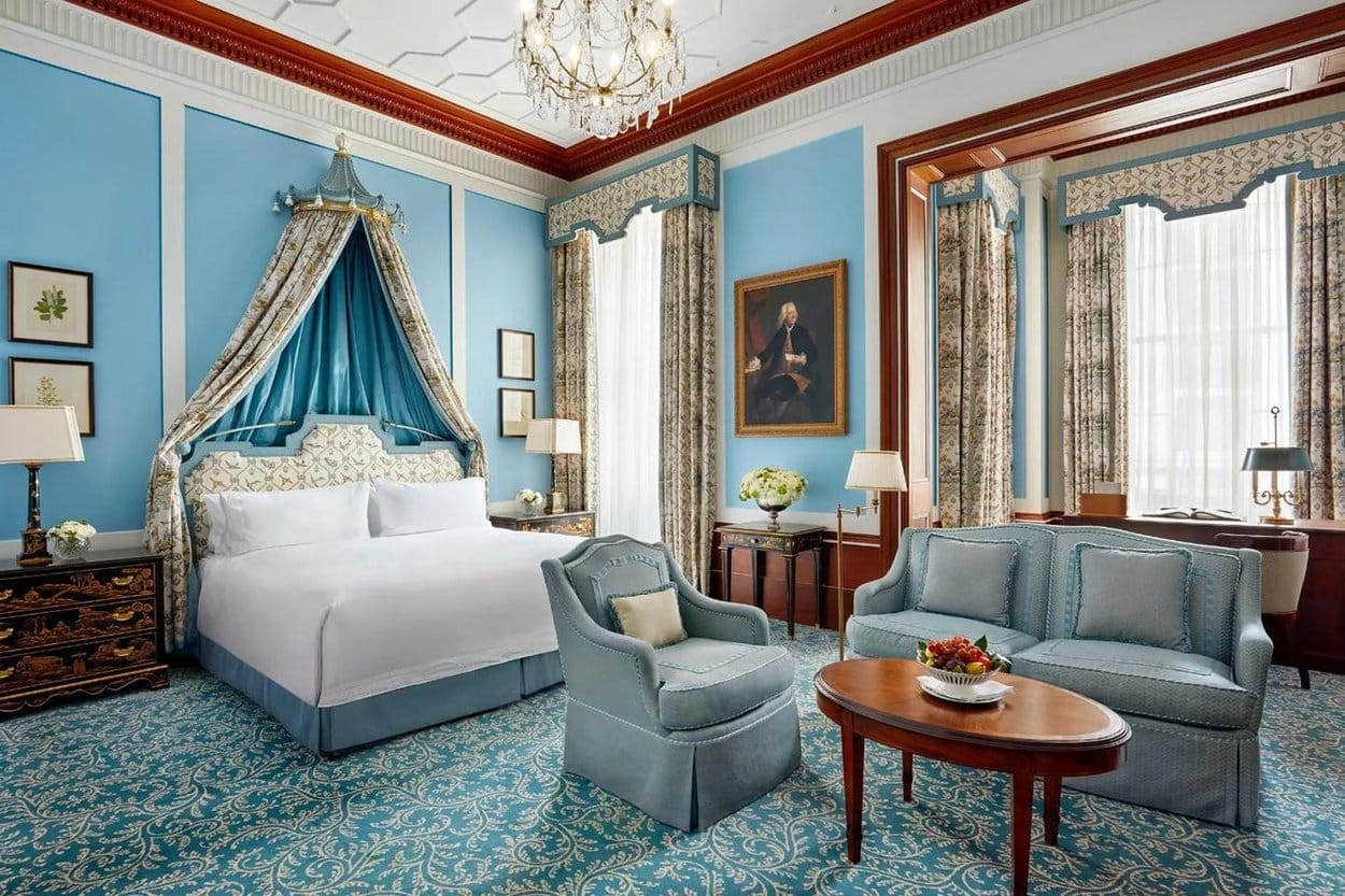 A suite at The Lanesborough, London, with a canopied bed, a chandelier and pale blue walls