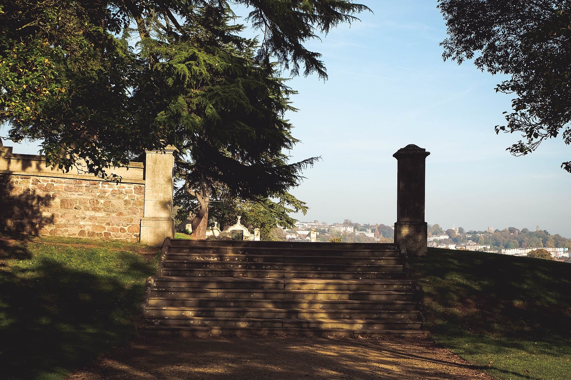 Stone steps and a gravel path at Ashton Court with the city of Bristol beyond