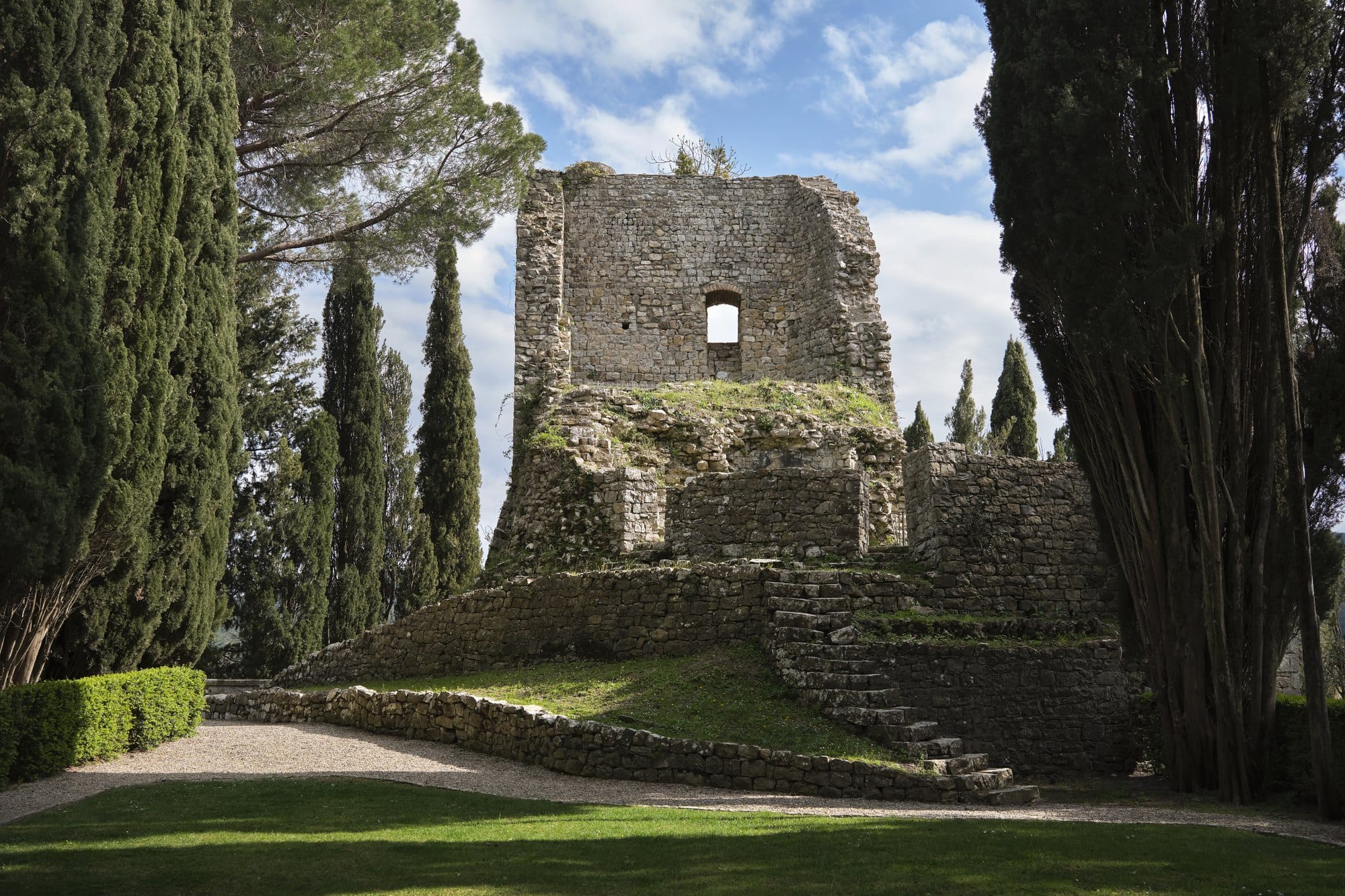 The ruins of the twelfth century castle at Castiglion del Bosco framed by cypress trees