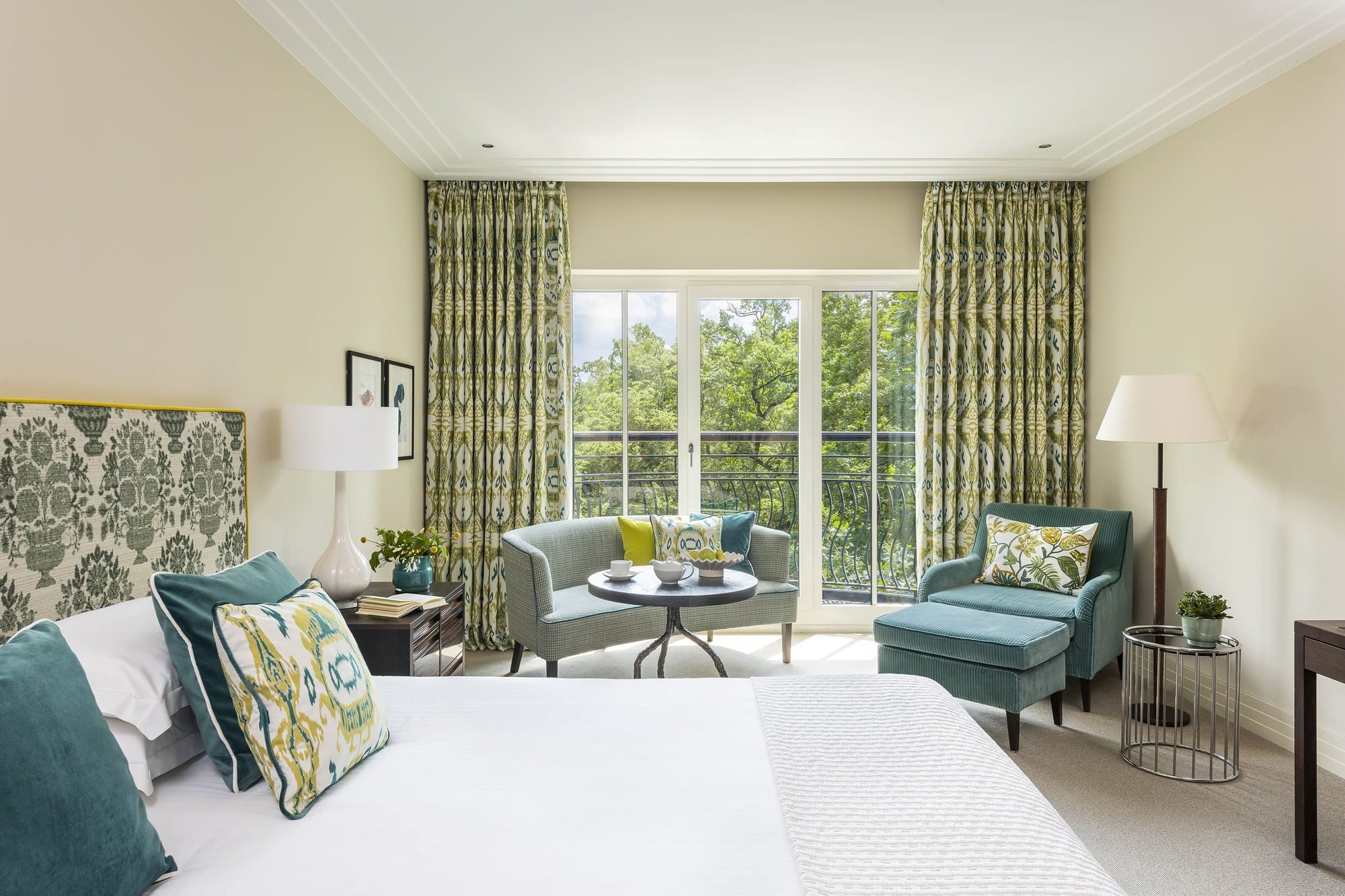 A Deluxe Park View Room at The Charles Hotel with green patterned curtains and a French balcony onto the trees