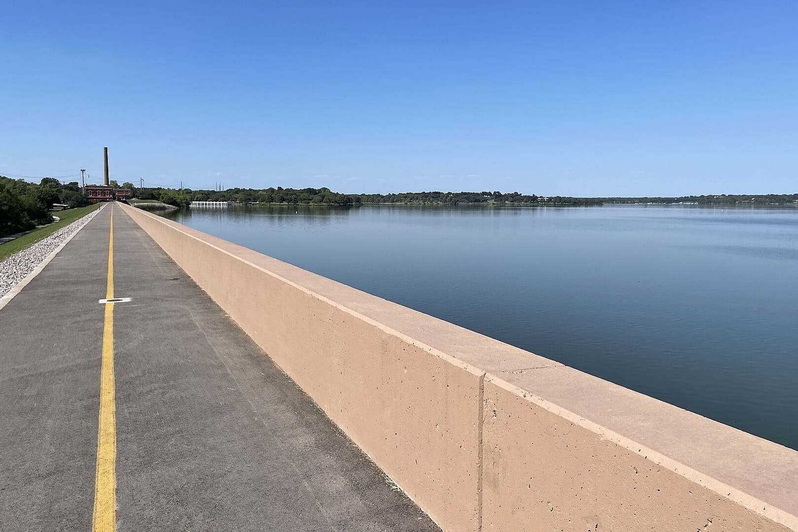 The paved path along the White Rock Lake spillway wall, with the lake stretching away to the right