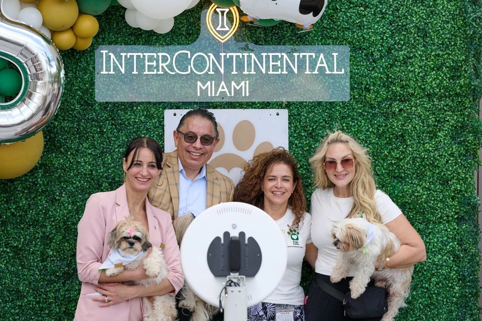 Guests and their dogs in front of the InterContinental Miami party backdrop