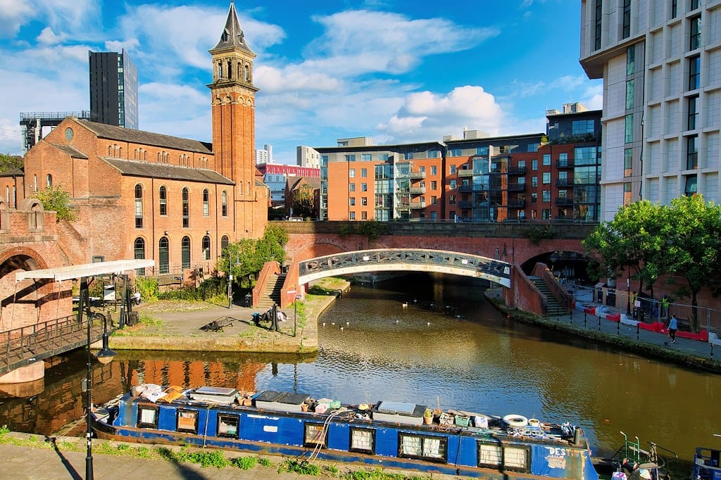 The Bridgewater Canal at Castlefield Basin with a narrowboat and an iron footbridge