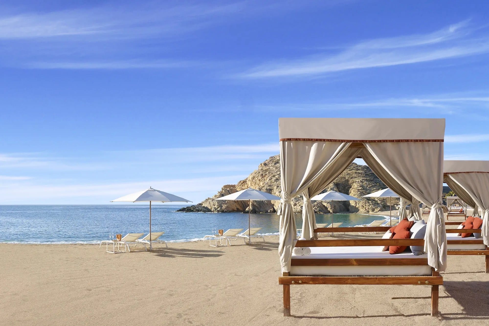 Canopied beach beds on the sand at Santa Maria Bay
