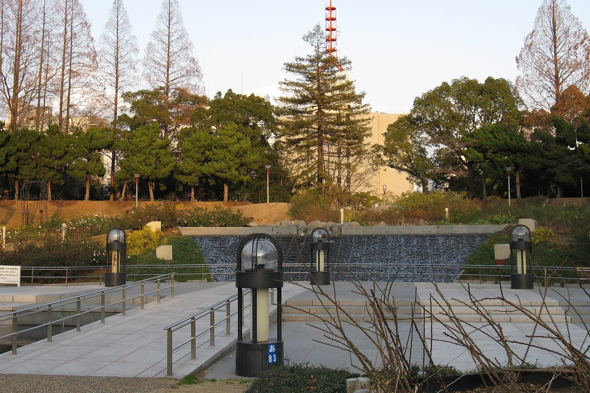 Paths, a cascade fountain and tall trees in Utsubo Park, Osaka