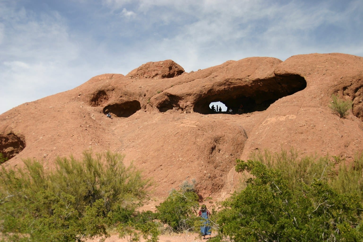 The red sandstone butte at Hole-in-the-Rock in Papago Park, with walkers in the window of the rock