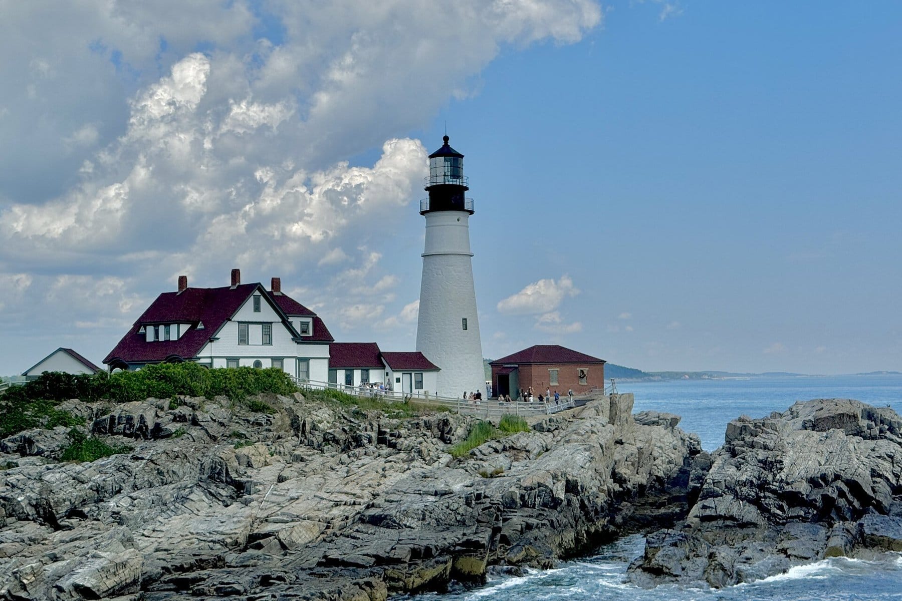 Portland Head Light and its keeper's house on the rocks at Fort Williams Park under a summer sky