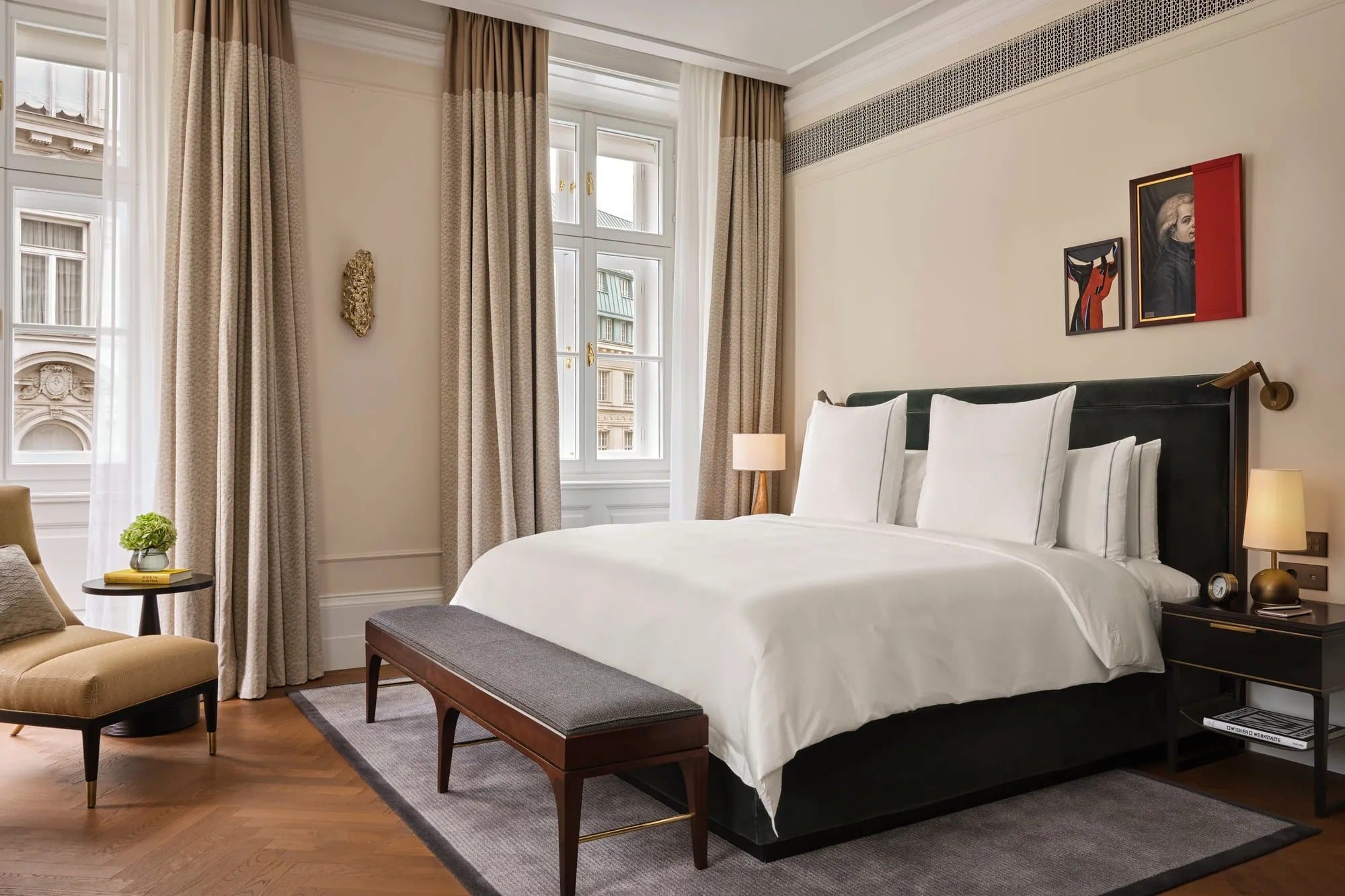 A bedroom in the Hofburg Suite at Rosewood Vienna with tall windows, a king bed and Viennese art on the wall