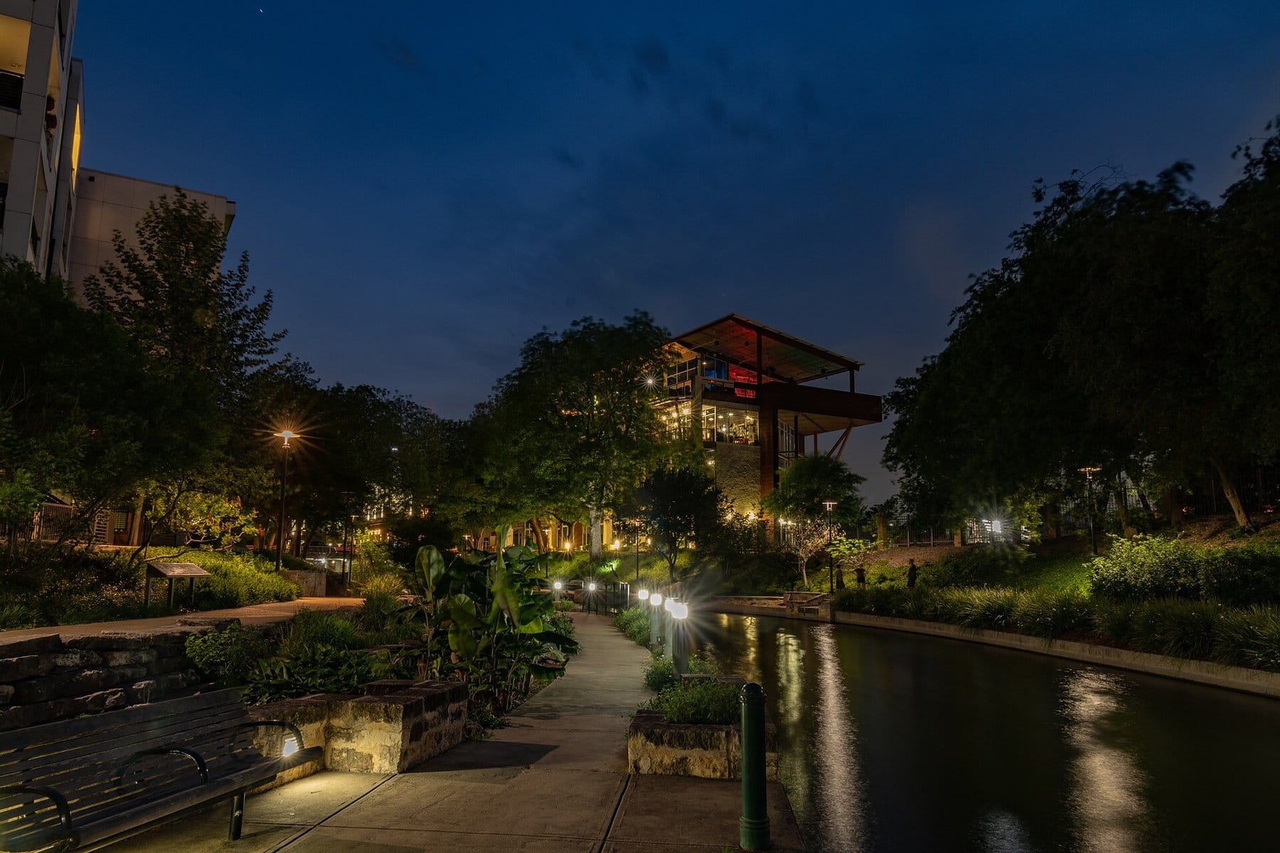 The River Walk path on the Museum Reach at dusk, lit by lamps beside the water