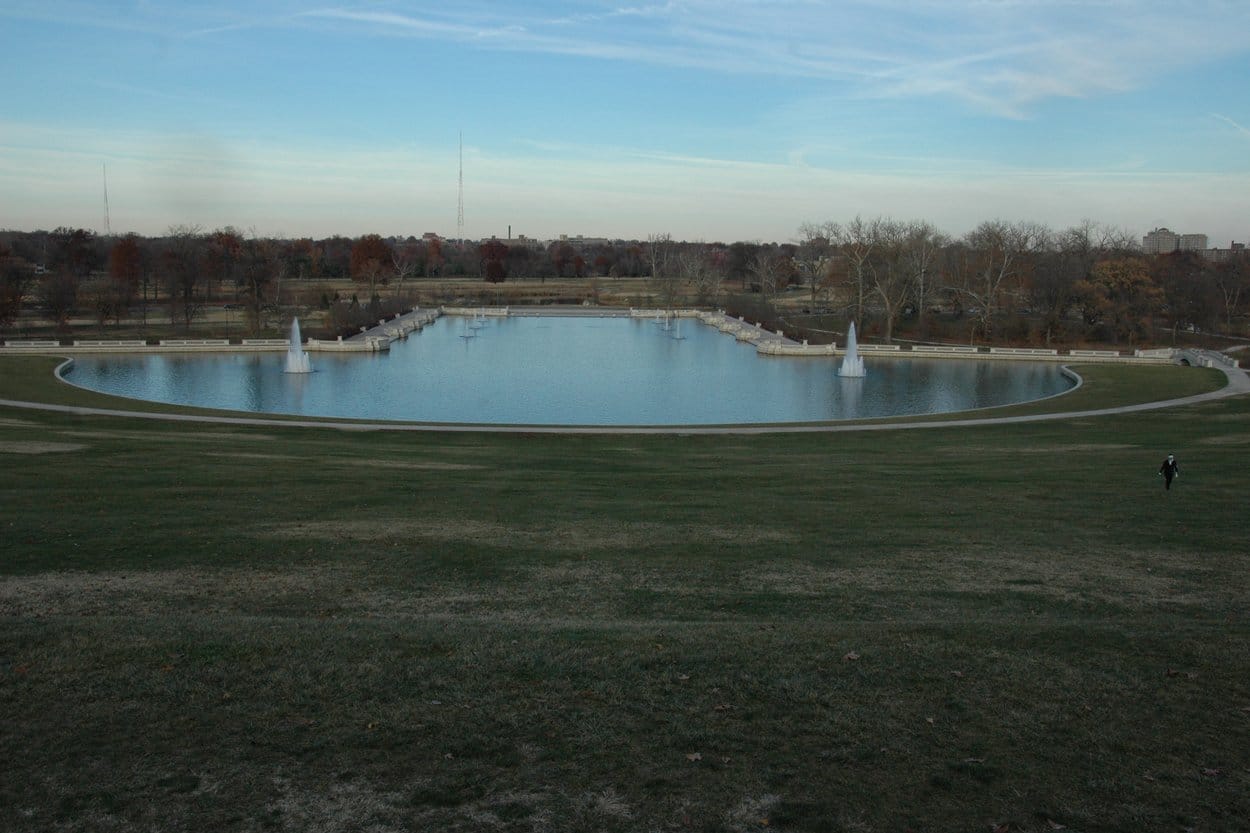 The Grand Basin in Forest Park, St. Louis, a long pool with fountains below a wide grass slope, bare trees beyond
