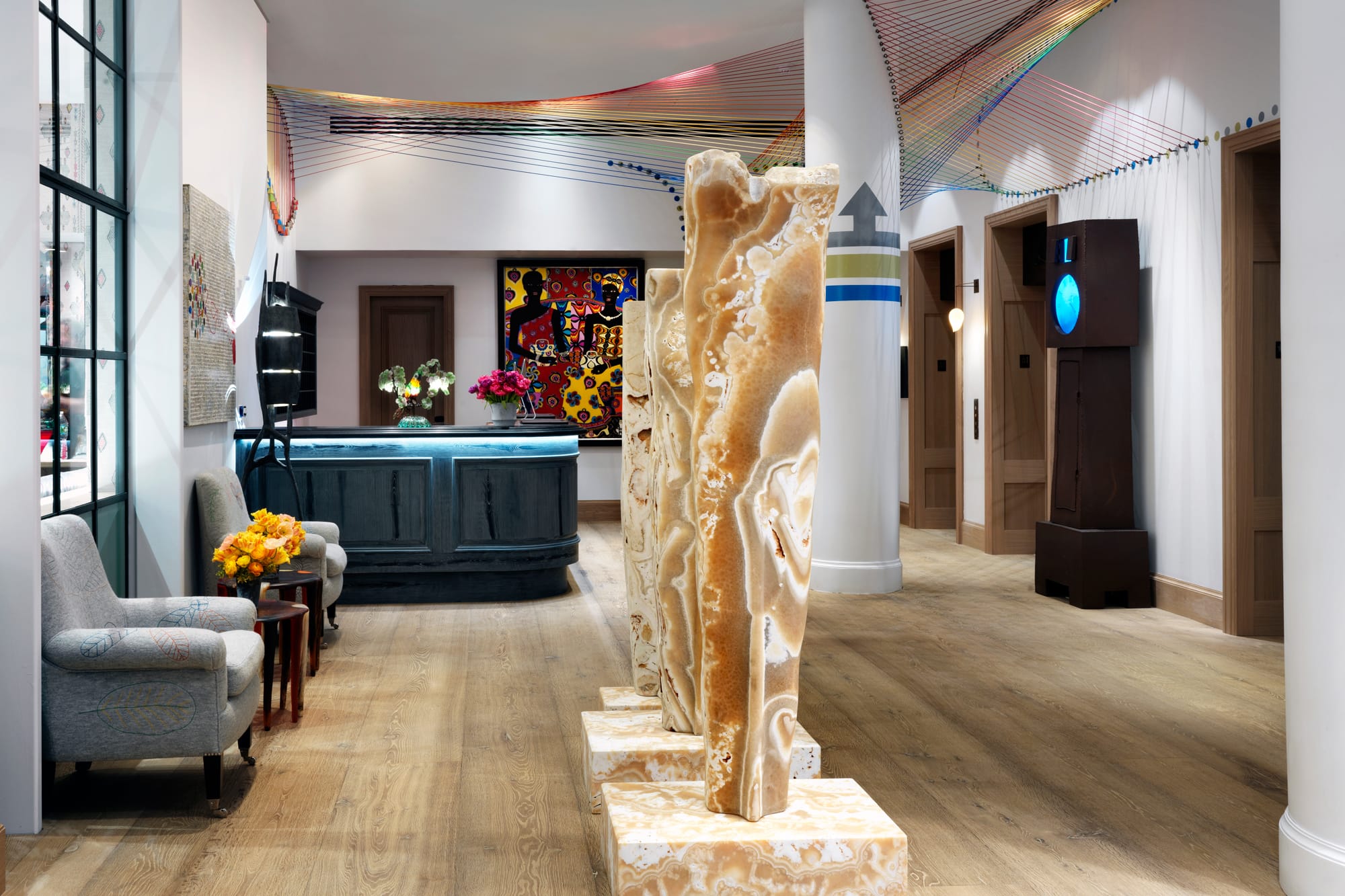 The lobby of The Whitby Hotel with carved stone sculptures, art and an armchair
