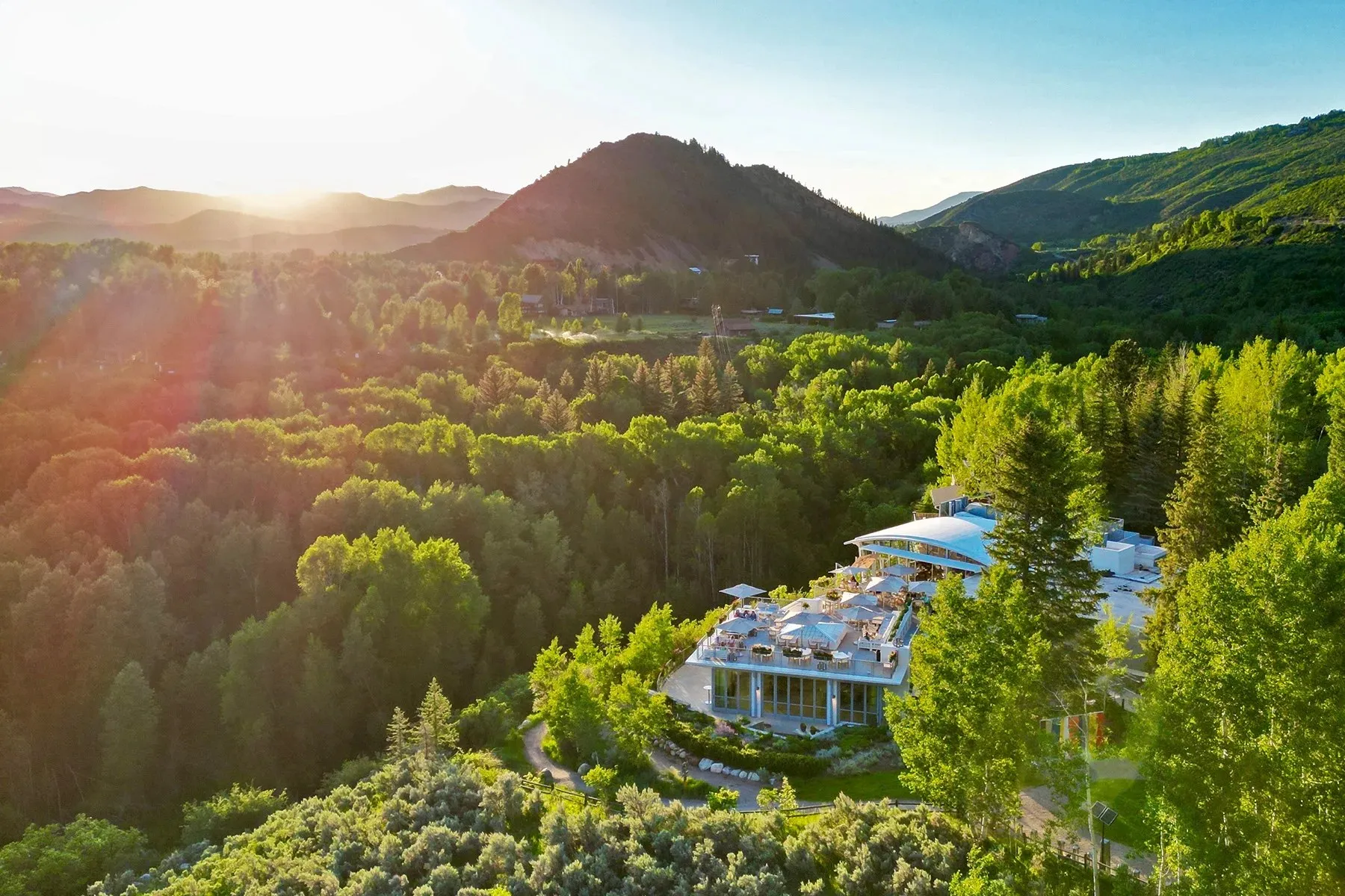 Aerial view of Aspen Meadows Resort among the trees of the Roaring Fork Valley at sunrise
