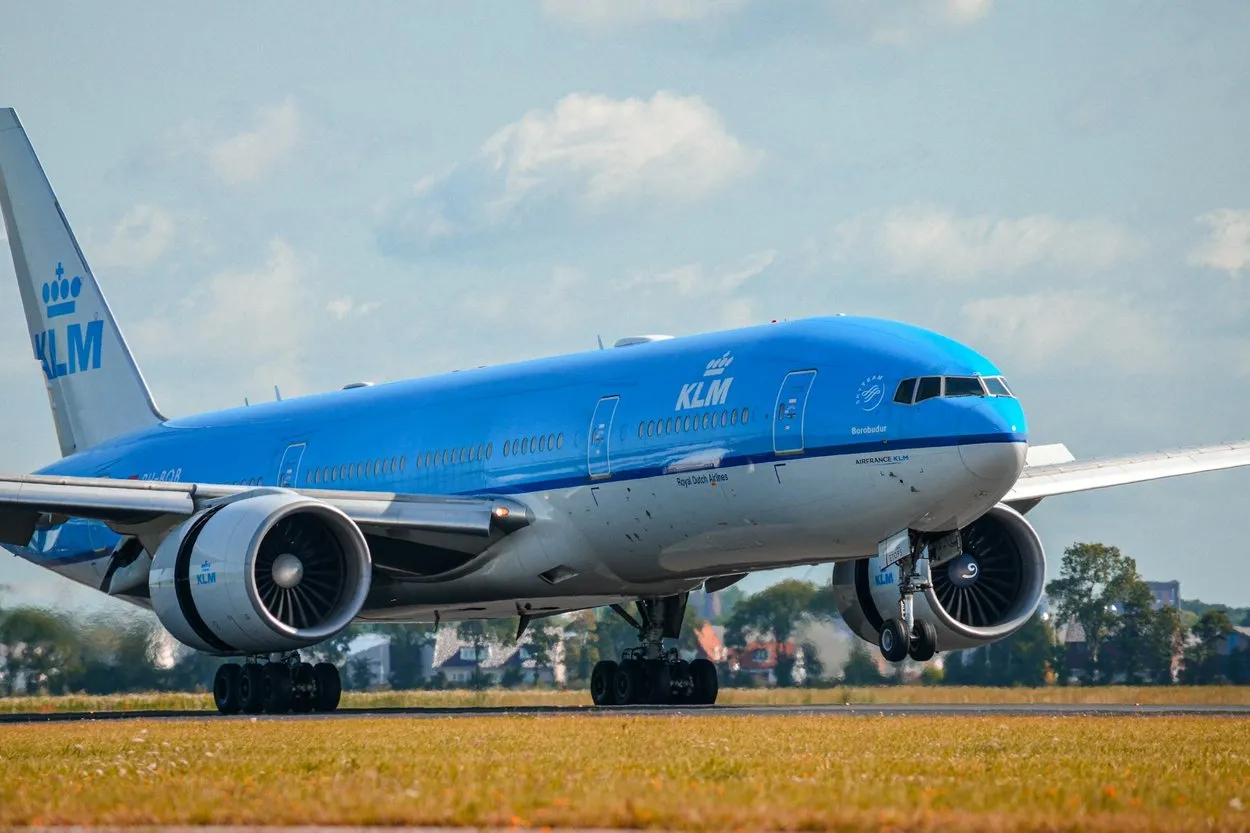 A blue KLM Boeing 777 on a runway