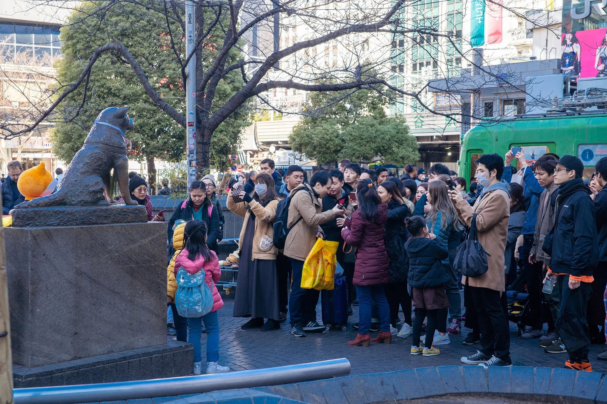 The bronze statue of Hachiko outside Shibuya Station, with a crowd of visitors photographing it