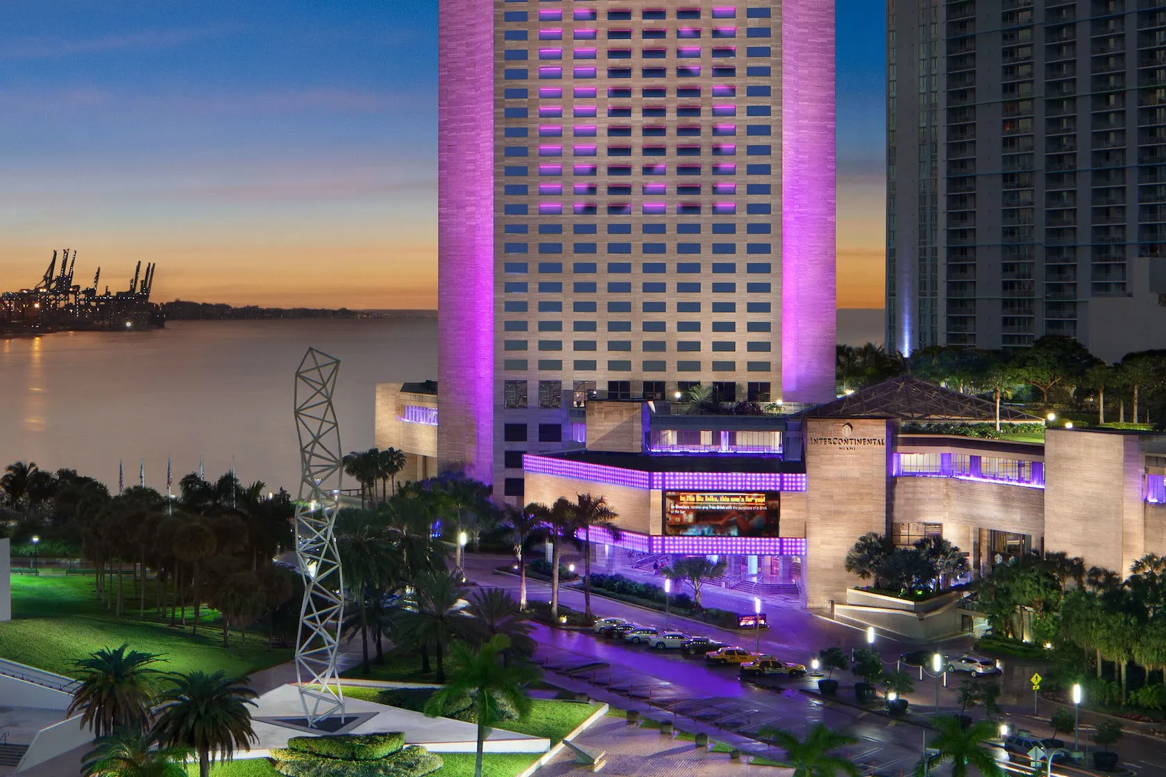 The InterContinental Miami tower at dusk on Biscayne Bay, with Bayfront Park in the foreground