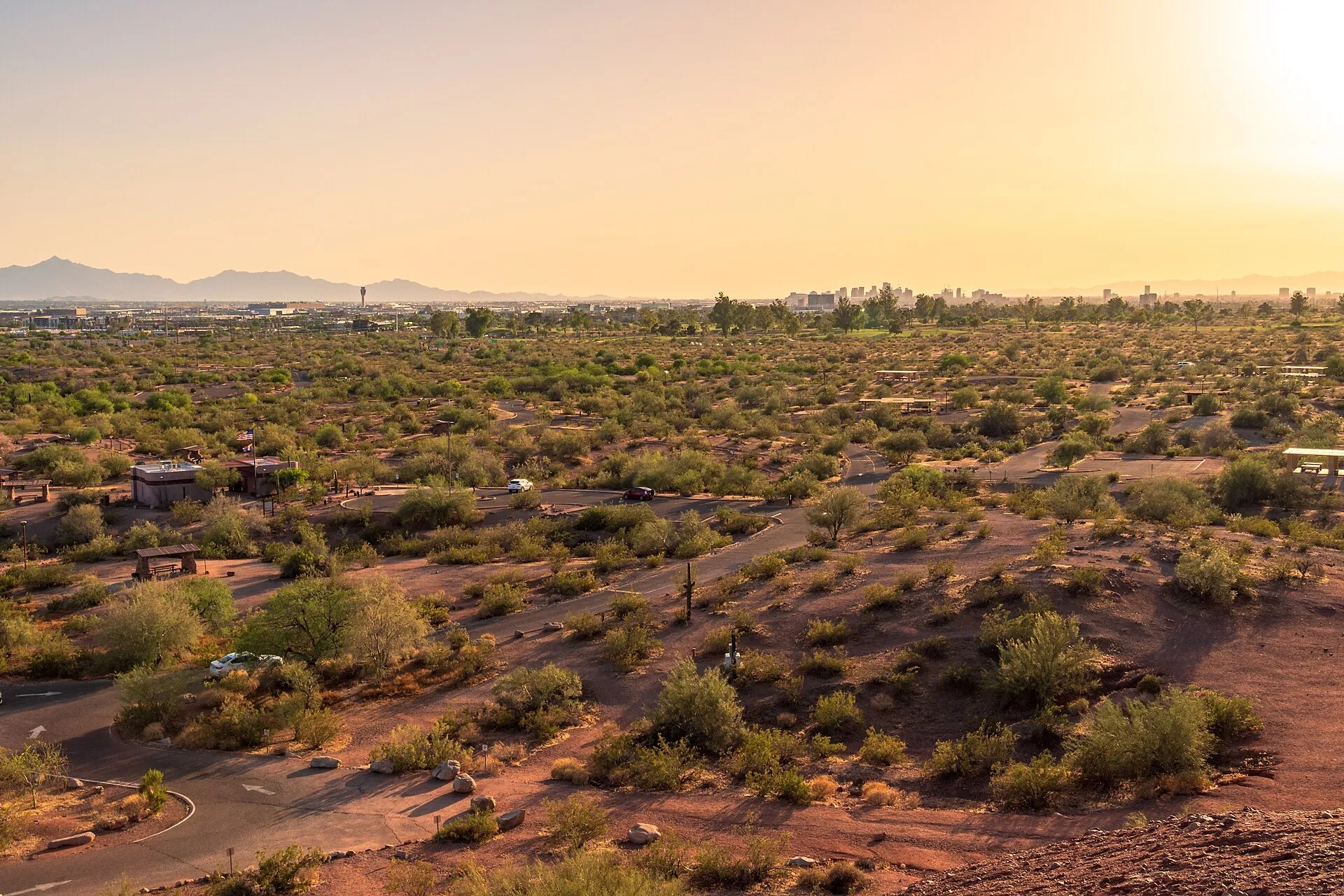 Paths winding through desert scrub in Papago Park, with downtown Phoenix and the mountains on the horizon