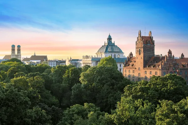 The treetops of Munich's Old Botanical Garden with the dome of the Palace of Justice and the towers of the Frauenkirche beyond, seen from The Charles Hotel