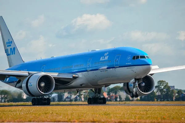 A blue KLM Boeing 777 on a runway