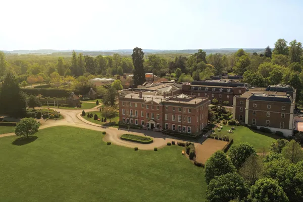 Aerial view of the red brick Georgian manor of Four Seasons Hotel Hampshire in its parkland