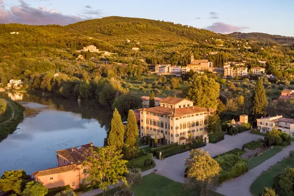 Aerial view of Villa La Massa and its gardens on a bend of the River Arno, with the Tuscan hills behind